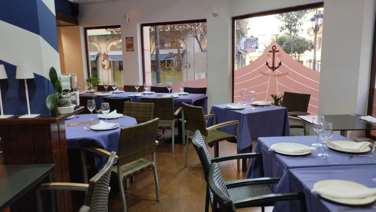 Comedor con mesas azules de la Arrocería El Galeón en el centro de Salamanca