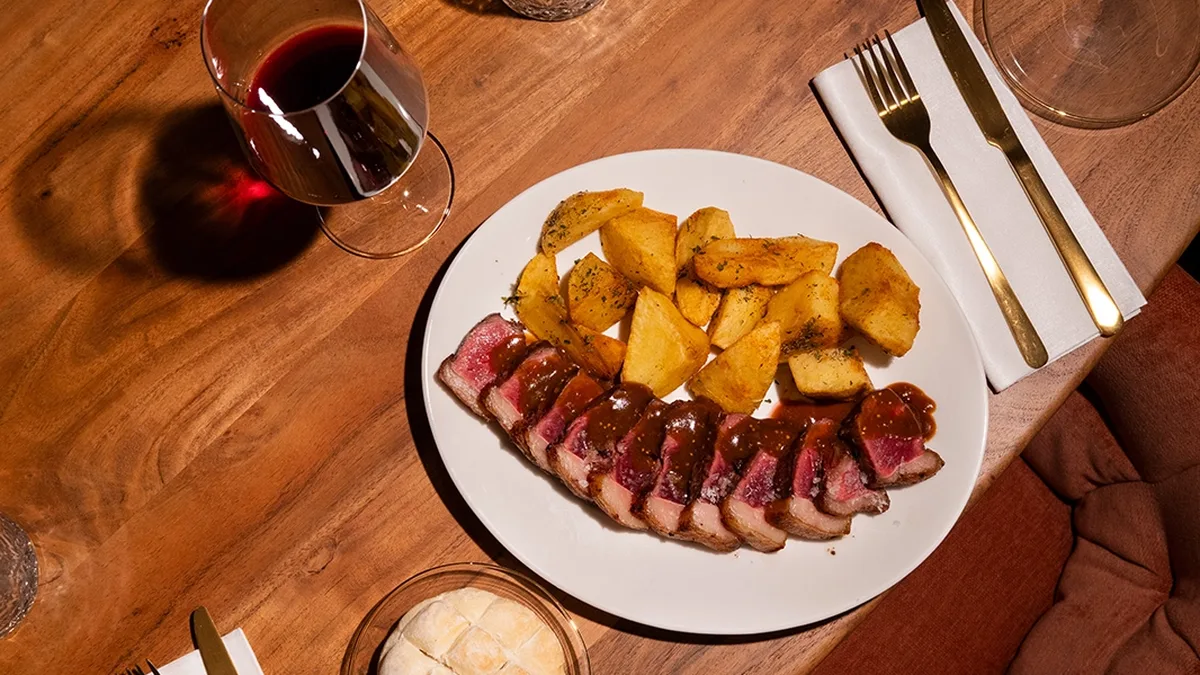 Plato y copa de vino en el restaurante La Bambalina de Valladolid