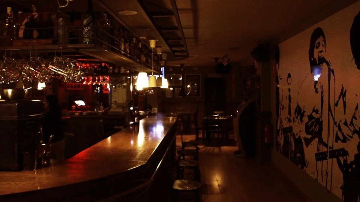 Interior del pub Les Paul en Valladolid, con la barra y un mural de rock