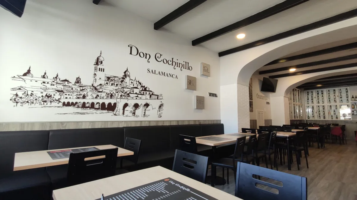 Comedor del asador Don Cochinillo con dibujo de Salamanca en la pared, calle Van Dyck