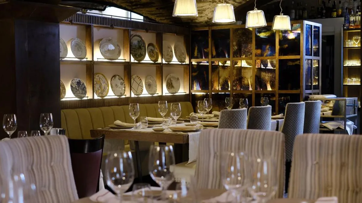 Sala del Mesón de Gonzalo con vajilla en las estanterías, restaurante de arroces y mariscos de Salamanca