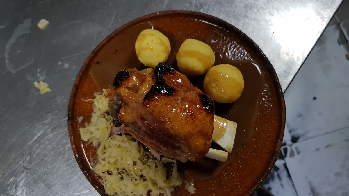 Plato de codillo con col del Erasmus Café & Biergarten en Salamanca