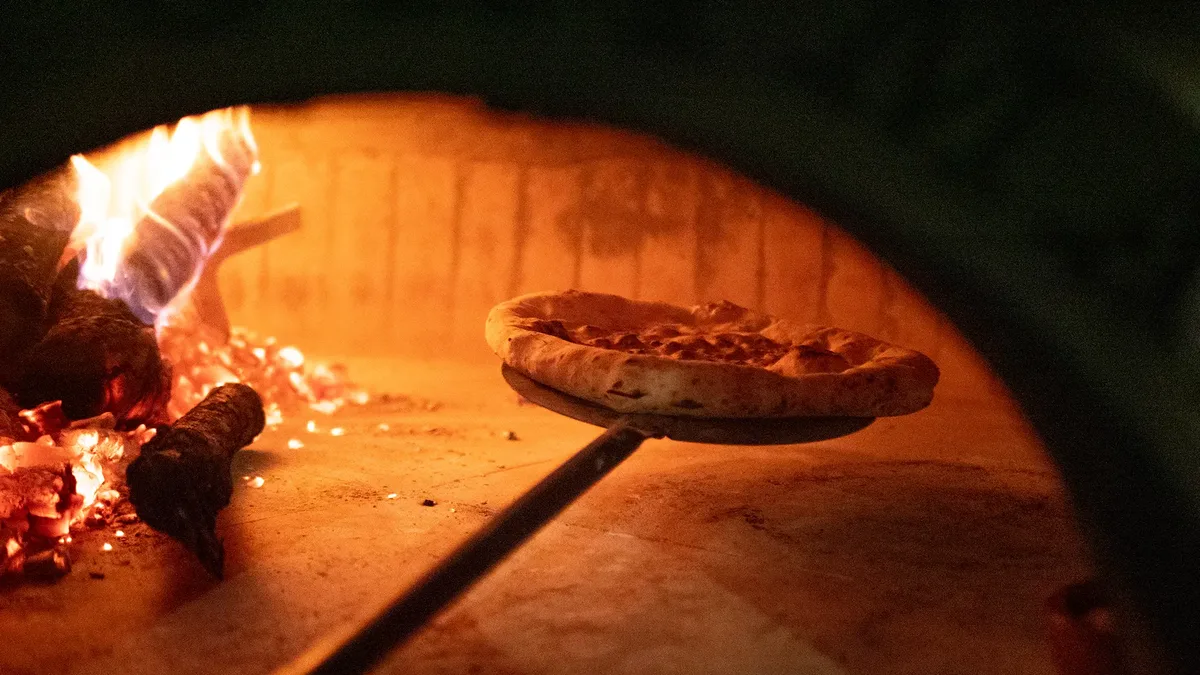 Pizza napolitana entrando al horno de leña en Salamanca