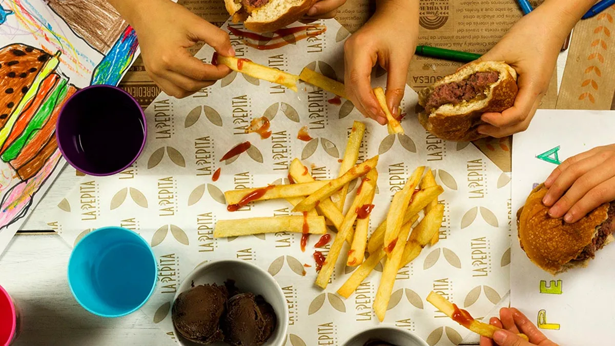 Hamburguesa y patatas sobre el mantel de La Pepita Burger Bar, Salamanca
