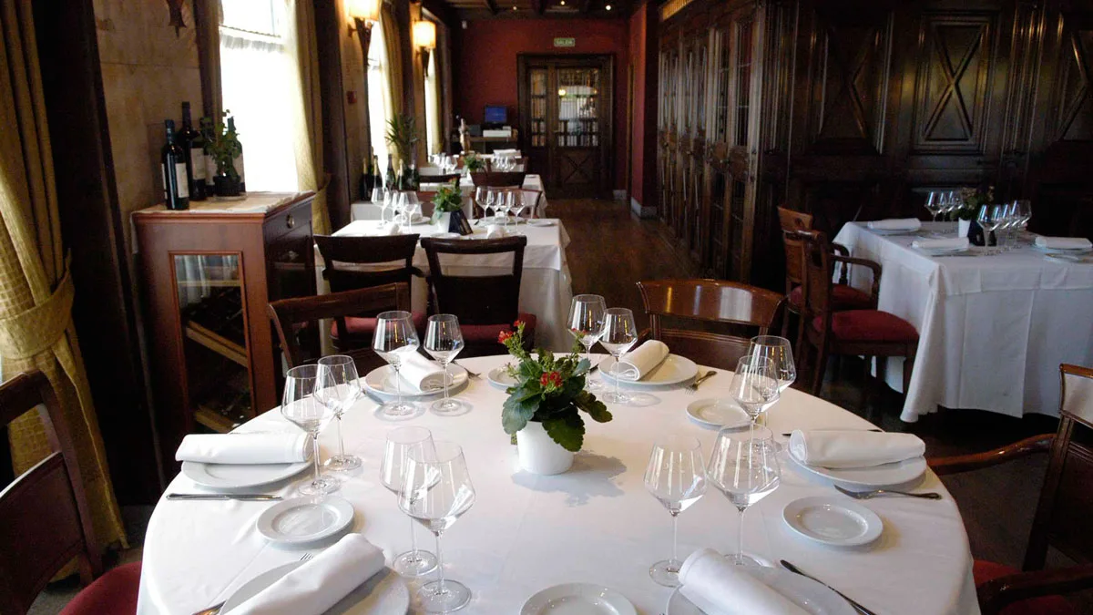 Comedor clásico con mesa redonda del restaurante Pucela, junto al Puente Romano de Salamanca